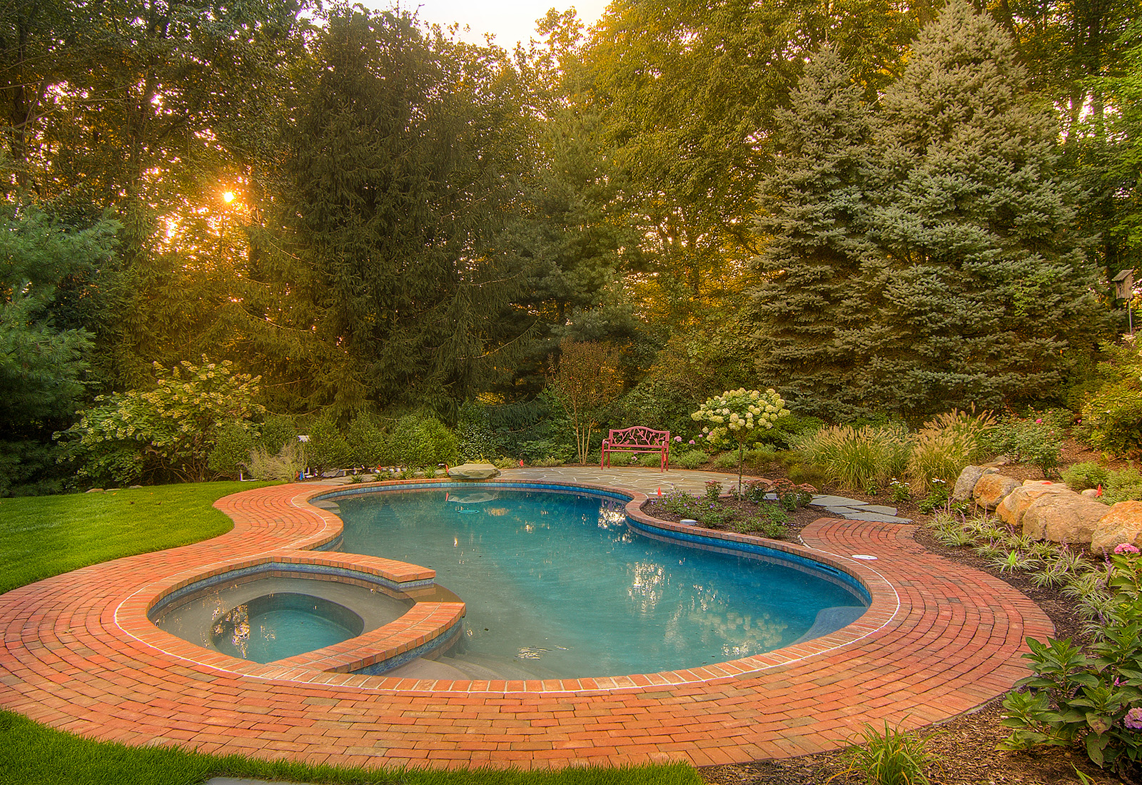 Gunite pool and spa with a brick patio.